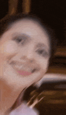 a woman is smiling and looking at the camera .