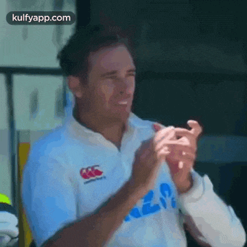 a man in a white shirt is clapping his hands