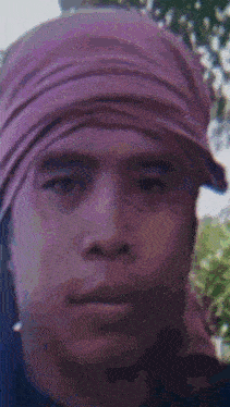 a close up of a man wearing a purple head scarf