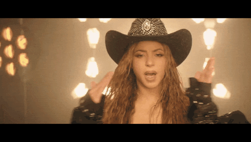 a woman wearing a cowboy hat is making a funny face