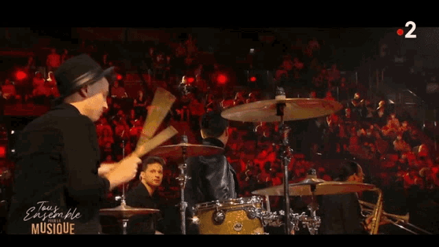 a group of people playing instruments on stage with the number 2 on the bottom