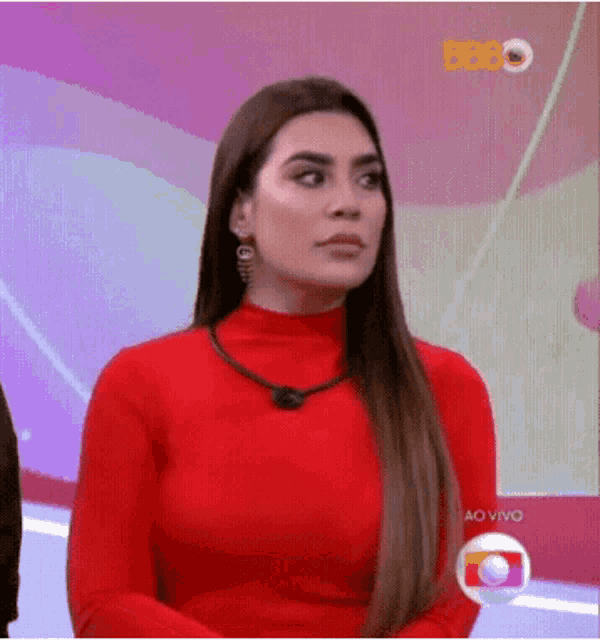 a woman in a red turtleneck sweater is sitting on a stage .