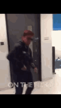 a man is standing in a hallway with the words " on the floor " on the wall behind him