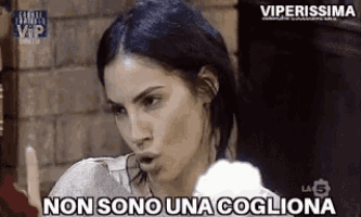 a woman is holding a piece of cotton candy and saying non sono una coglia .