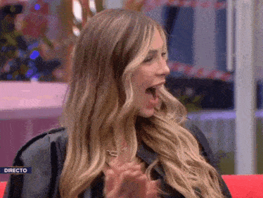 a woman is sitting on a red couch with her mouth open and the word directo on the bottom right