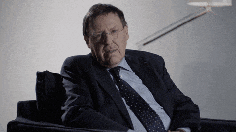 a man in a suit and tie sits on a chair