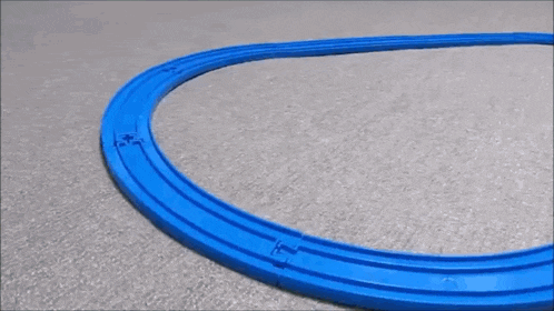 a toy train is going down a track on a carpet .