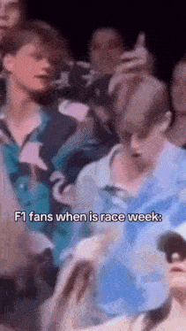a group of people are gathered in a dark room and one of them says f1 fans when is race week .