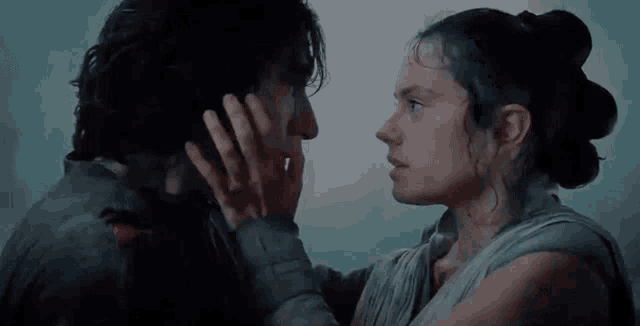 a man and a woman are touching each other 's faces in a dark room .