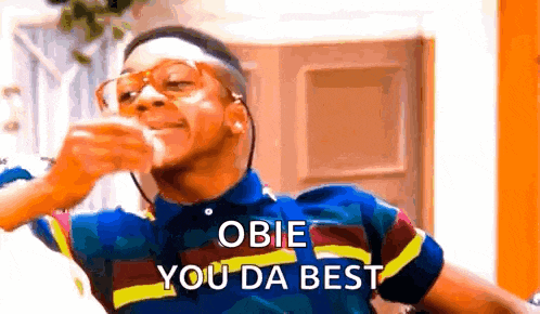 a man wearing glasses and a plaid shirt is drinking from a glass and says `` obie you da best '' .