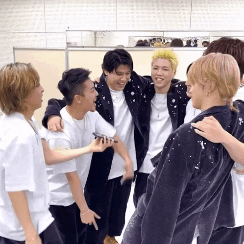 a group of young men are standing next to each other and laughing .