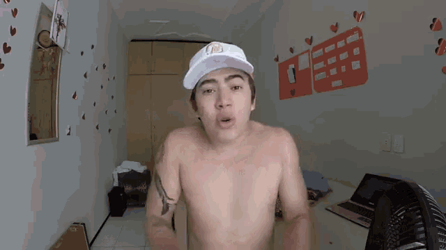 a shirtless man wearing a white hat with the letter j on the front