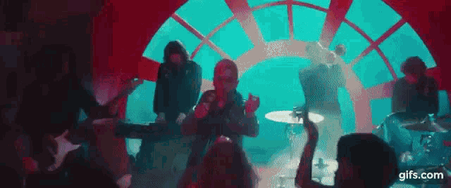 a group of people are playing instruments in front of a crowd .