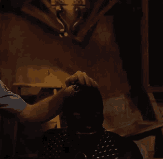a man in a blue shirt is putting a mask on a woman 's head