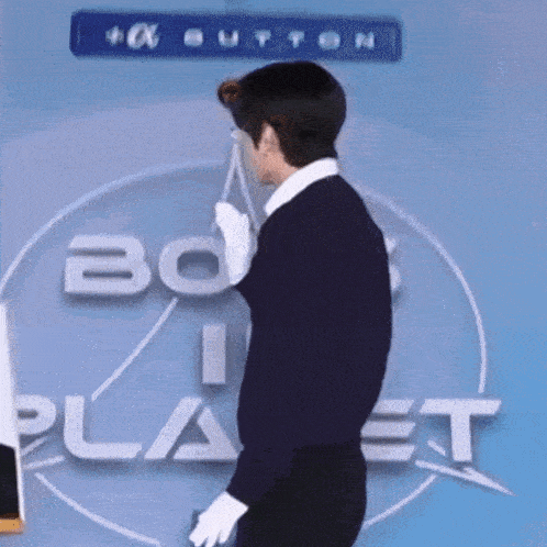 a man is standing in front of a sign that says ' bo planet ' on it .