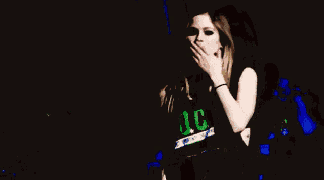a woman blowing a kiss while holding her hand to her face