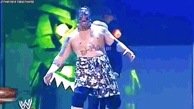 a shirtless wrestler in a hawaiian outfit is walking on a stage
