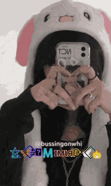 a person wearing a bunny hat is taking a picture of themselves