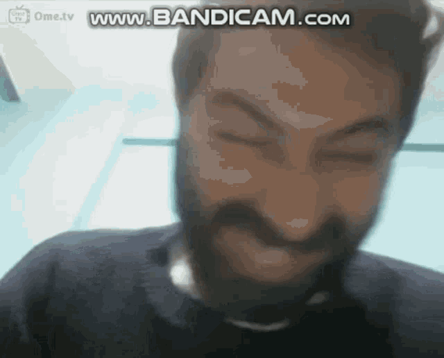 a man with a beard is making a funny face in front of a screen that says www.bandicam.com .