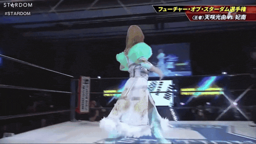 a woman in a white dress is standing in a wrestling ring with the word stardom on the bottom