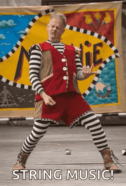 a man in striped pants and a red vest is dancing in front of a banner that says string music