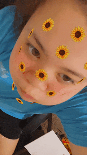 a person with sunflowers on their face and a blue shirt