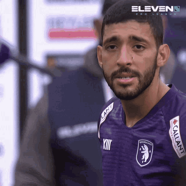 a man with a beard wearing a purple shirt that says xii on it