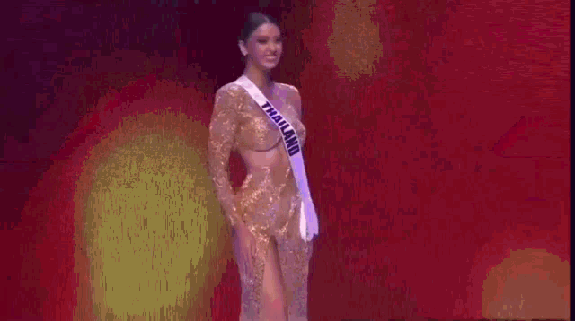 a woman is walking down a runway wearing a high slit dress and heels .
