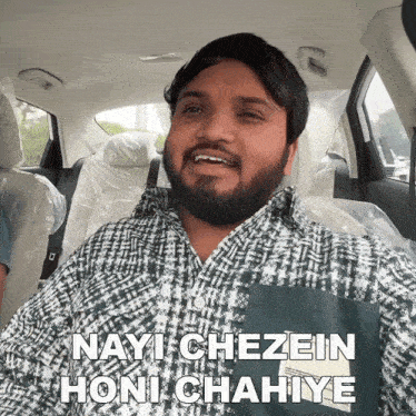 a man in a car with the words nayi chezein honi chahiye