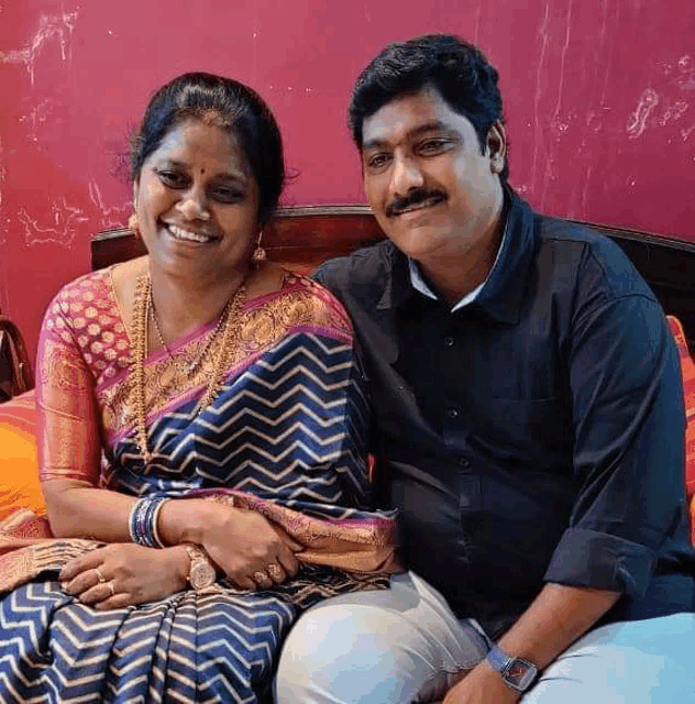 a man and a woman are sitting next to each other on a bed and smiling .