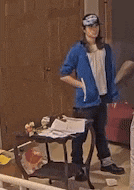 a woman in a blue jacket is standing in front of a door .