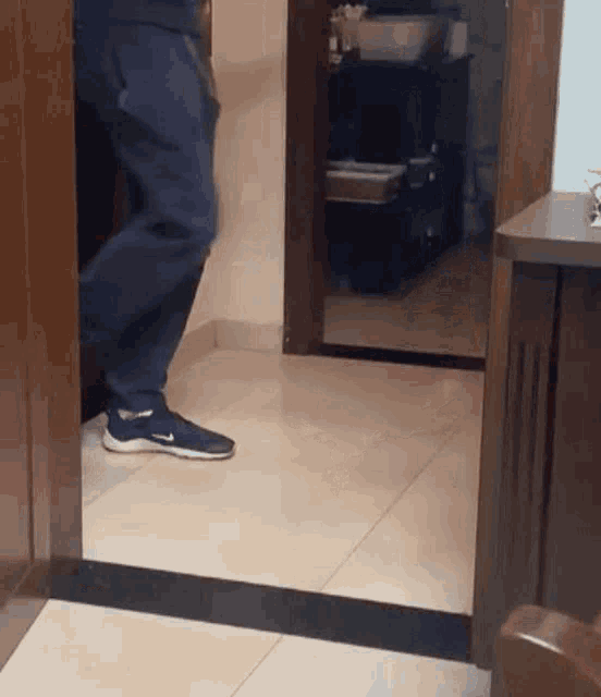 a person wearing nike shoes standing in a hallway