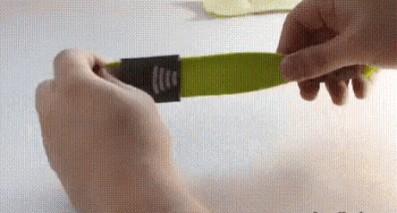 a person is holding a green object with a black label on it .