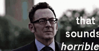 a man in a suit and tie with glasses and the words `` that sounds horrible '' behind him .