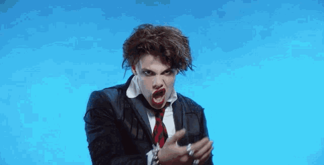 a man in a suit and tie is making a funny face while wearing red lipstick .
