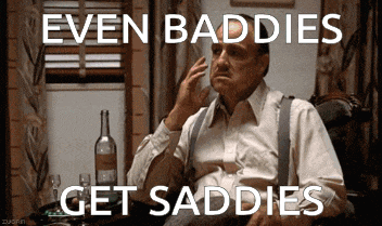 a man sitting in a chair with the words even baddies get saddies on the screen
