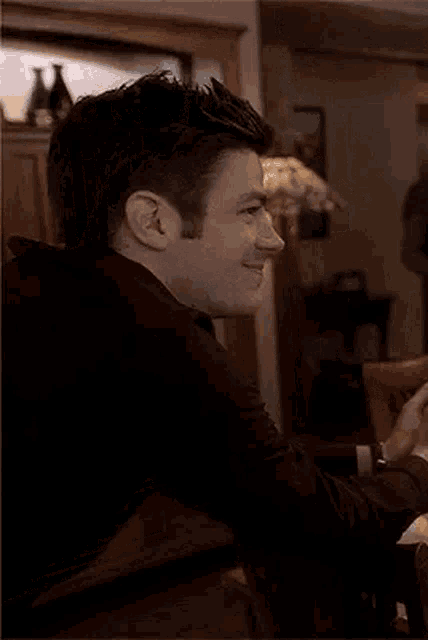 a man is sitting at a dining table in a living room .