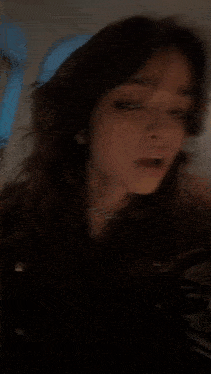 a blurry picture of a woman standing in a dark room .