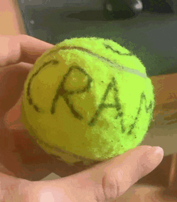 a person is holding a tennis ball that has the word cram written on it