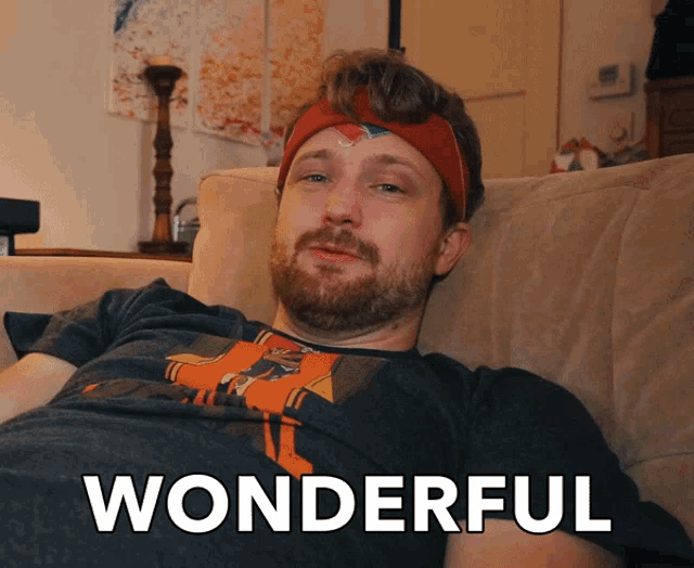 a man wearing a headband is laying on a couch with the word wonderful written below him