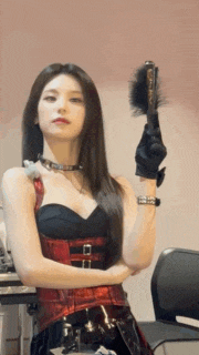 a woman in a red and black outfit is holding a brush in her right hand .