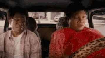 two men and a woman are sitting in the back seat of a car .