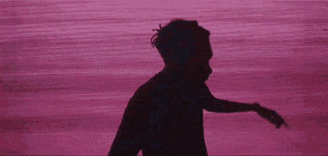 a silhouette of a person with a purple background