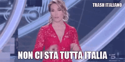 a woman in a red dress is standing on a stage and saying non ci sta tutta italia