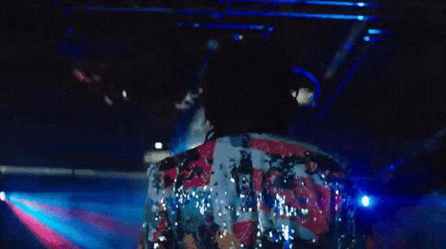 a disco ball hangs above a crowd of people in a club
