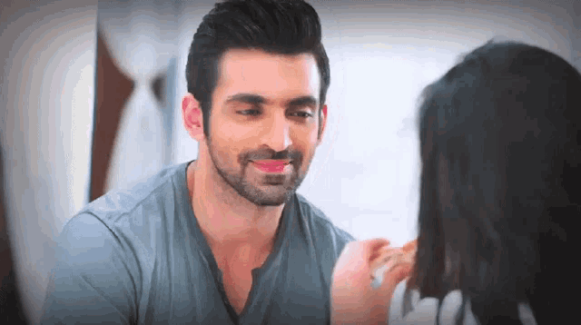 a man and a woman are looking at each other and the man is smiling .