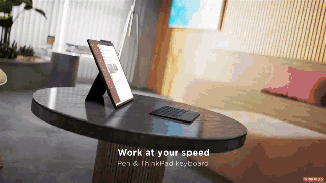 a computer on a table with the words work at your speed pen and thinkpad keyboard