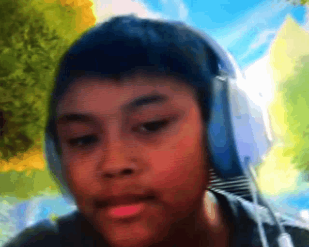 a young boy wearing headphones looks at the camera