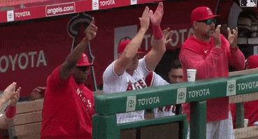 a group of baseball players in a dugout with toyota advertisements on the wall behind them
