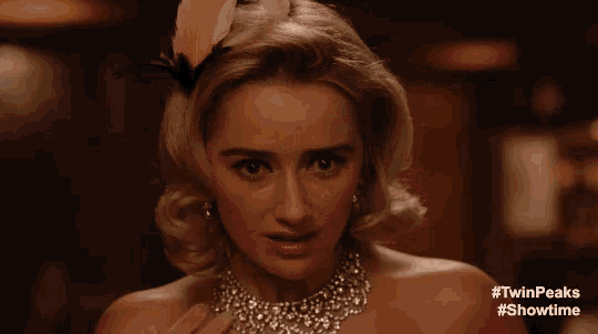 a woman with a flower in her hair is wearing a necklace ..